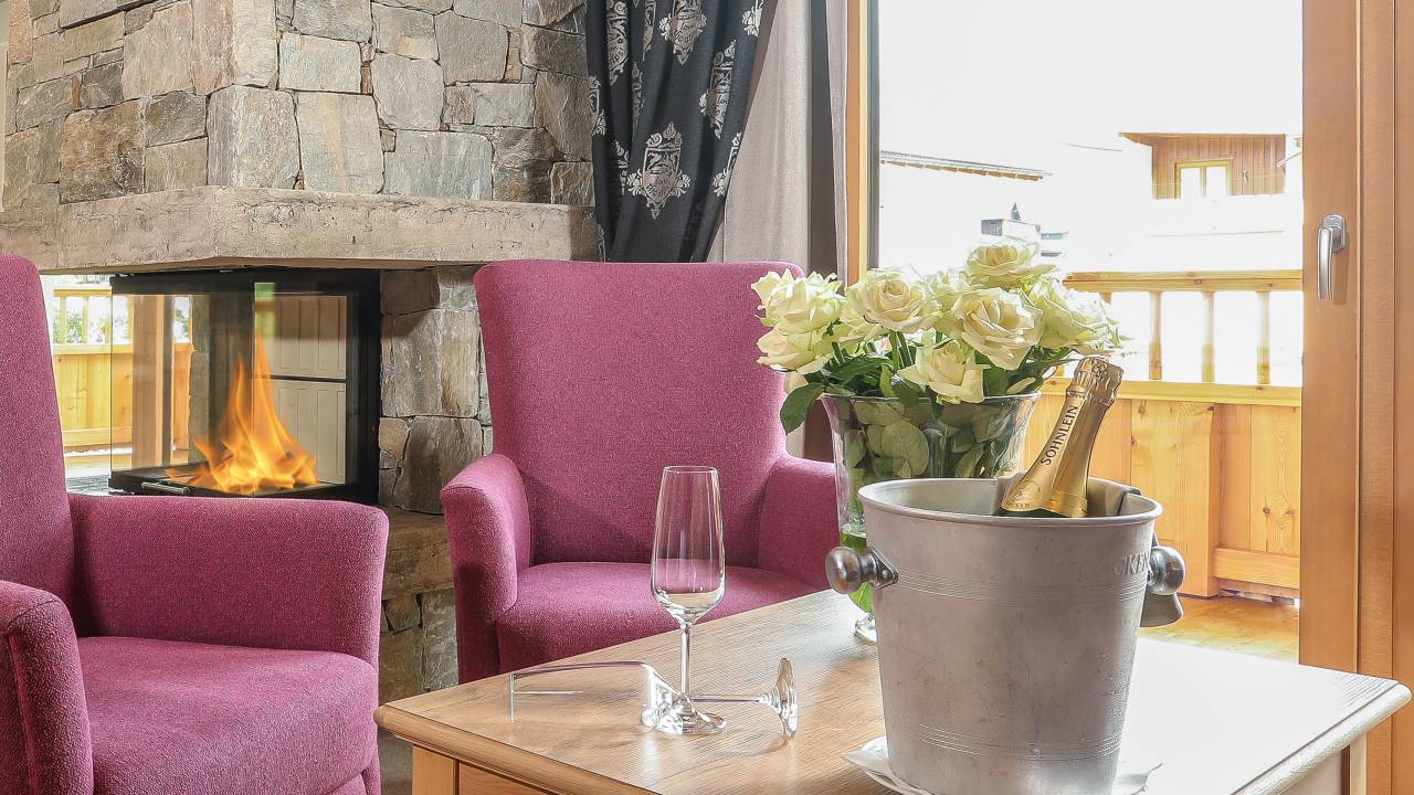 Tisch mit ekt, Sofa-Ecke, Kamin - Luxus Wellness Suite im Adults only resort