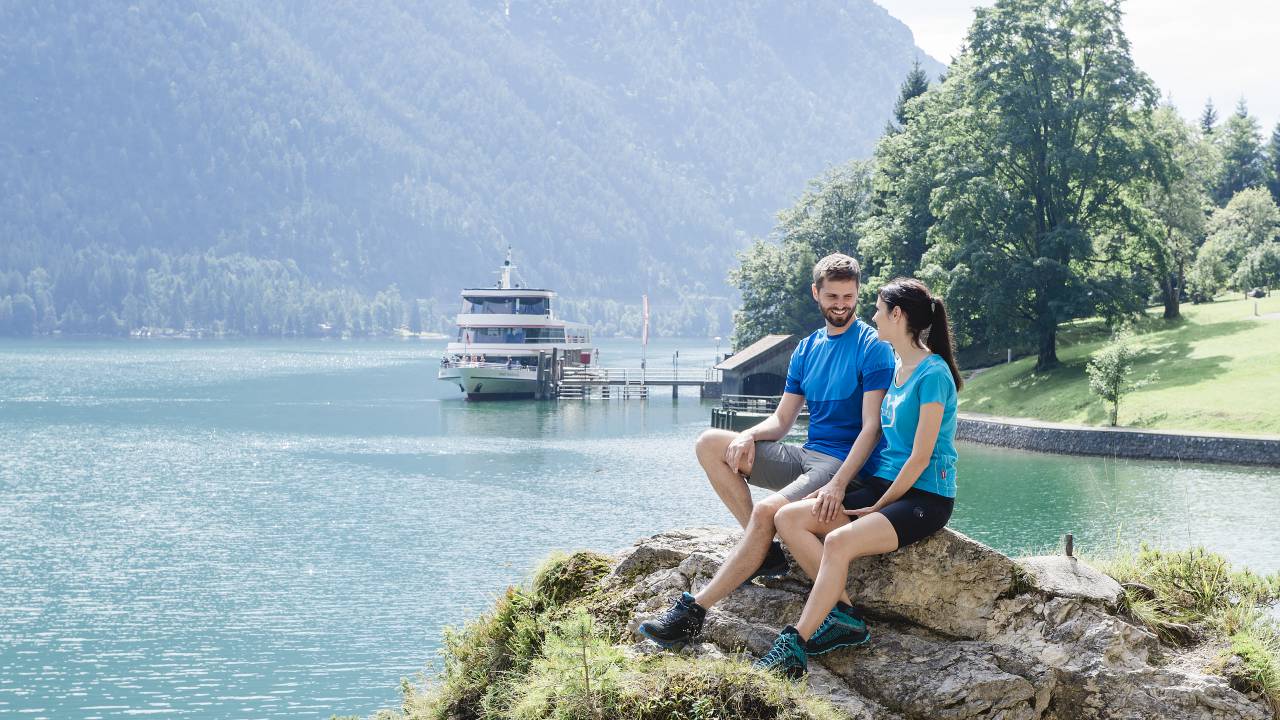 Paar sitzt am Ufer des Achensee